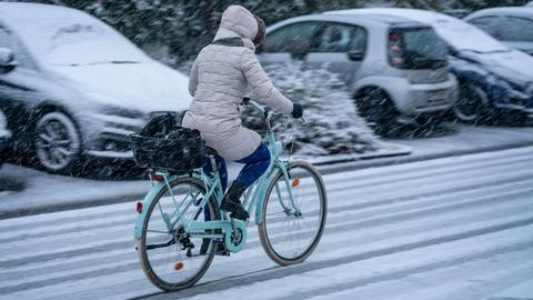Radfahrerin auf verschneiter Straße