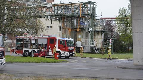 Feuerwehrfahrzeuge und Einsatzkräfte in einem Industriepark mit vielen Rohren.