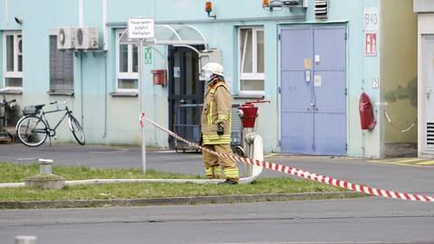 Ein Feuerwehrmann steht vor einer Fabrikhalle.