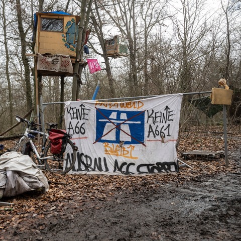 "Keine A66" steht auf einem Protestplakat an einem Baumhaus  im Wald