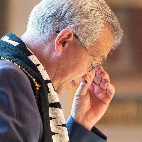 Bildkombination aus zwei Foto: links Feldmann im Profil., wie er seinen Kopf nachdenklich nach unten neigt; rechts wie er im Flugzeug vorne stehend eine Ansage macht.