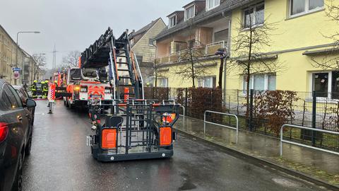 Einsatzfahrzeuge stehen in Straße vor Häusertrakt