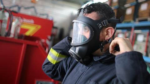 Feuerwehrmann zieht Atemschutzmaske auf