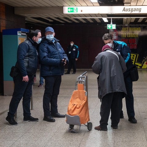Eine ältere Frau (M) wird während einer Kontrolle der 3G-Maßnahmen im Frankfurter ÖPNV zur Eindämmung der Coronavirus-Pandemie in einer Haltestelle kontrolliert.