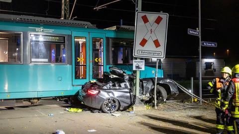 Nach dem Zusammenstoß mit einer U-Bahn ist das schwer beschädigte Unfall-Auto zwischen Bahn und Schranken eingeklemmt.