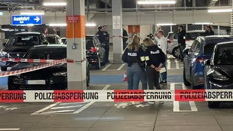 Polizisten und Absperrung in Parkhaus mit Autos