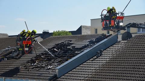 Feuerwehrleute bei Nachlöscharbeiten eines Dachstuhlbrands.