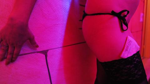 Beine einer Prostituierten mit Geldschein im Strumpf