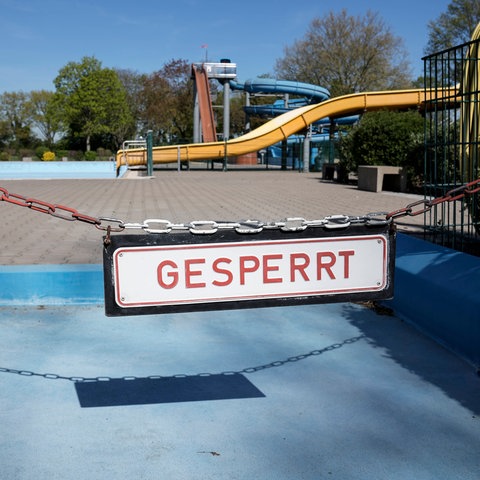 Ein Schild mit der Aufschrifft "Gesperrt" hängt an einem Becken in einem Freibad.