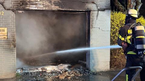 Feuerwehrleute bei Löscharbeiten an einer Garage