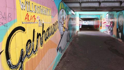 Blick in eine Fußgänger-Unterführung, deren Wände bunt mit Graffitis besprüht sind.