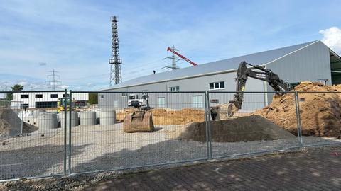 Die Baustelle in Frankfurt-Sossenheim - das Gerichtszelt ist bereits zu erkennen. Ein Bagger steht im Vordergrund. 