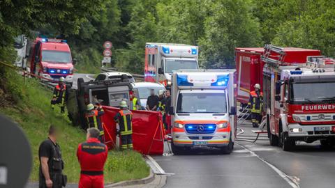 Rettungskräfte auf einer Straße neben einem auf dem Dach liegenden Transporter