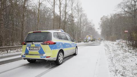 Polizeiautos stehen auf einer verschneiten Straße in Hessen.