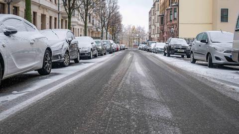 Schneebedeckte Autos entlang glatter Straße