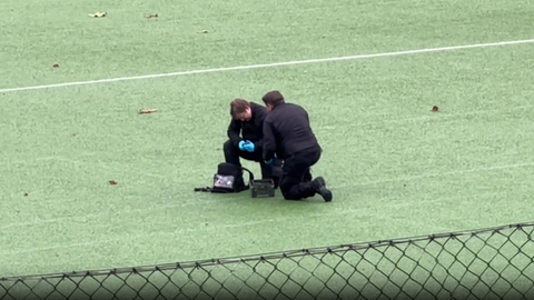 Sprengstoffexperten untersuchen den verdächtigen Gegenstand auf einem Sportplatz nahe des hr-Geländes.