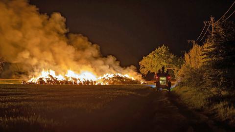 Flammen schlagen aus Heuballen auf Feld