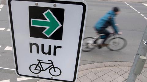 Auf einem Verkehrsschild sind ein grüner Pfeil und ein Fahrrad zu sehen.