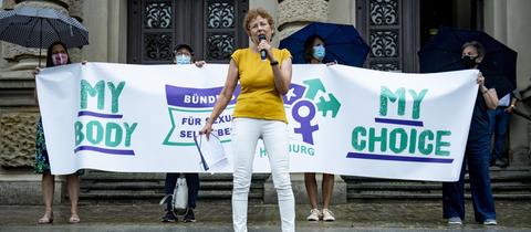 Kristina Hänel steht vor einem Transparent vor dem Zivilgerichtsgebäude in Hamburg
