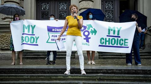 Kristina Hänel steht vor einem Transparent vor dem Zivilgerichtsgebäude in Hamburg