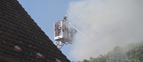 Feuerwehrmann auf Drehleiter mit Schlauch