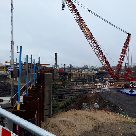 Auf der Baustelle an der Hanauer Hauptbahnhofbrücke steht ein Kran.