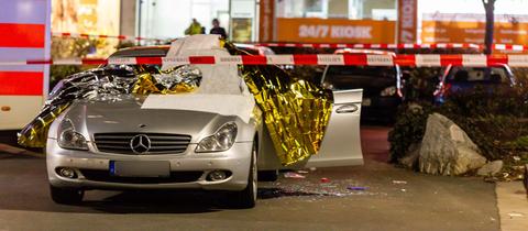 Ein mit Thermofolie abgedecktes Auto am Tatort im Hanauer Stadtteil Kesselstadt
