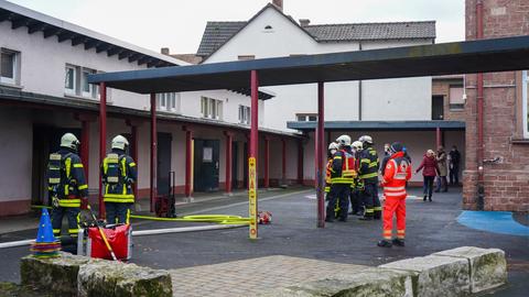 Einsatzkräfte der Feuerwehr nach dem Brand an der Theodor-Heuss-Schule in Hanau-Steinheim.