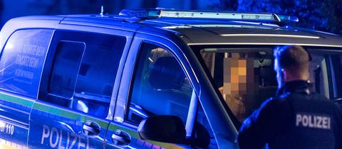 Festgenommener Mann sitzt in einem Polizeiauto