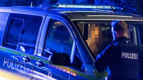 Festgenommener Mann sitzt in einem Polizeiauto