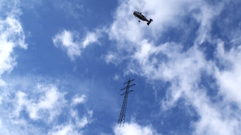 Ein Schwerlast-Helikopter transportiert einen Strommast im Odenwald ab