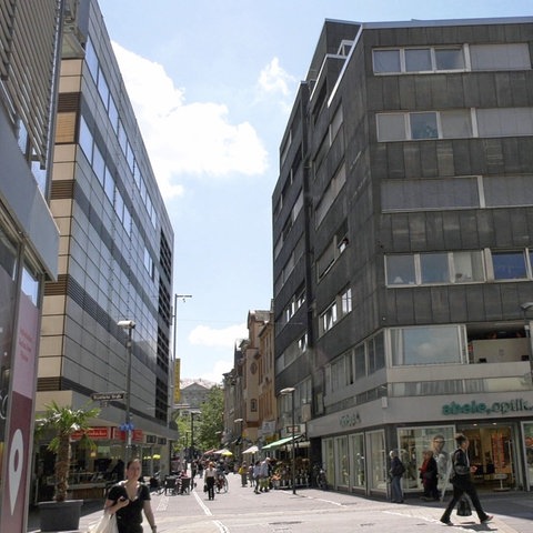 Eine Straße in der Fußgängerzone, rechts hohe Gebäude.