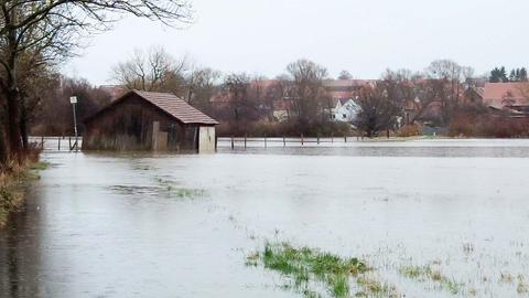 Ein Hütte steht inmitten eines überschwemmten Gebietes.
