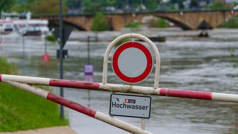 Ein Warnschild "Hochwasser" ist am Zurlaubener Ufer aufgestellt. Für Trier hat der Deutsche Wetterdienst die höchste Warnstufe vergeben.