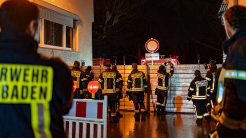 Mitglieder der Wiesbadener Feuerwehr bauen zwischen zwei Häusern eine Schutzwand gegen Hochwassera auf.