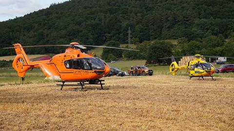 Zwei Rettungshubschrauber stehen auf einem Feld