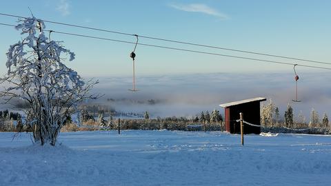 Schnee bedeckt den Hoherodskopf, am Himmel Nebel.