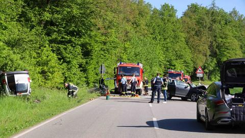 Unfallstelle auf Landstraße: ein Auto liegt auf dem Dach, ein anderes ist schwer beschädigt, Feuerwehr und Polizei vor Ort