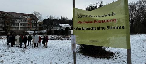 Eine Gruppe erzürnter Bürger trifft sich am Geilebach auf dem Grundstück, das bebaut werden soll