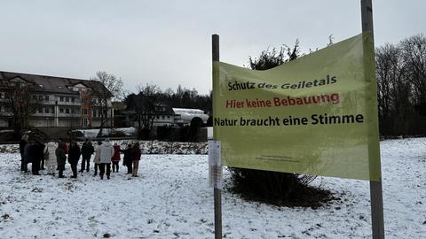 Eine Gruppe erzürnter Bürger trifft sich am Geilebach auf dem Grundstück, das bebaut werden soll