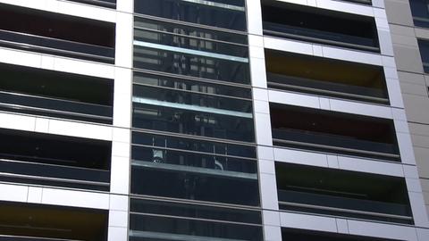 Eine gläserne Hausfassade - in der Mitte sieht man einen Auto-Aufzug, der ein weißes Auto nach oben befördert
