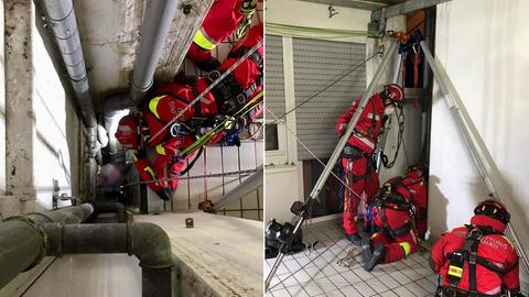 Höhenretter der Feuerwehr sprechen mit dem verletzten Mann im Schacht.
