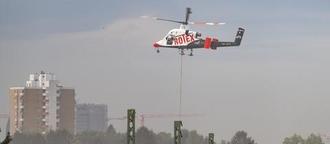 Ein Hubschrauber mit der Aufschrift "Rotex", darunter Strommasten.