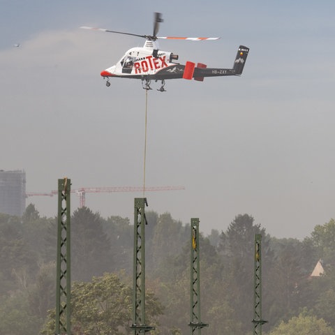 Ein Hubschrauber mit der Aufschrift "Rotex", darunter Strommasten.