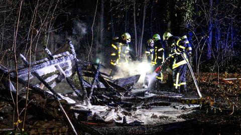 Feuerwehrleute löschen die Hütte.