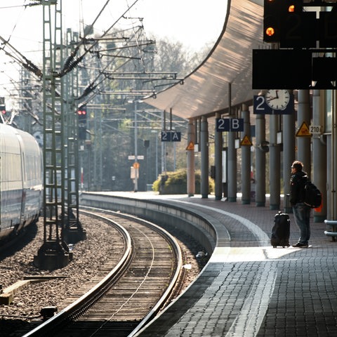 Eine Reisende steht mit ihrem Koffer am Bahnsteig in Kassel-Wilhelmshöhe.