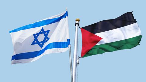 Zwei Nationalflaggen nebeneinander vor hellblauem Hintergrund: links die israelische, rechts die palästinensische.