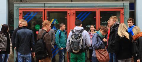 Schülerinnen und Schüler stehen vor einer Jugendherberge