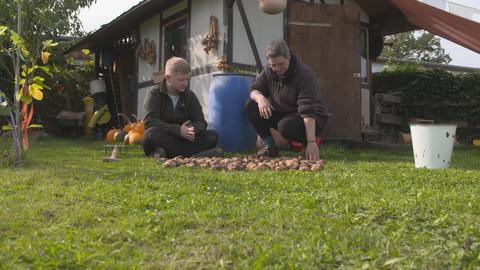Reporter Simon Rustler und Selbstversorgerin Steffi Scheidler sitzen vor der Kartoffelernte.