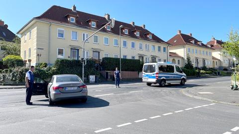 Ein Polizeiauto, ein Kfz und zwei Polizisten stehen auf einer Straße und kontrollieren.